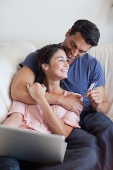 Portrait of a lovely couple booking their holidays online in their living room