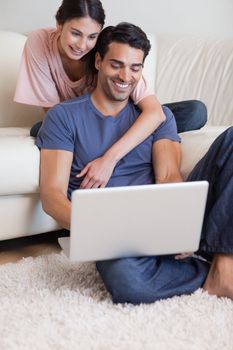 Portrait of a happy couple using a notebook in their living room