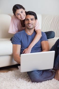 Portrait of a lovely couple using a laptop in their living room