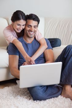 Portrait of a charming couple using a laptop in their living room