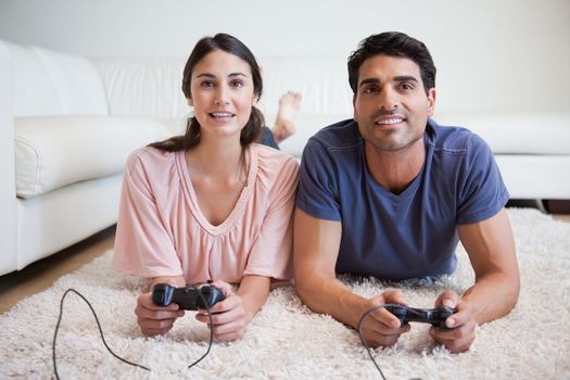 Young couple playing video games in their living room