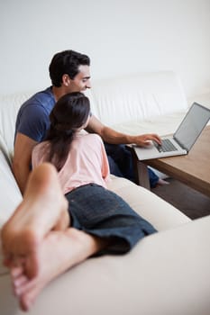 Above view of a couple using a laptop in their living room