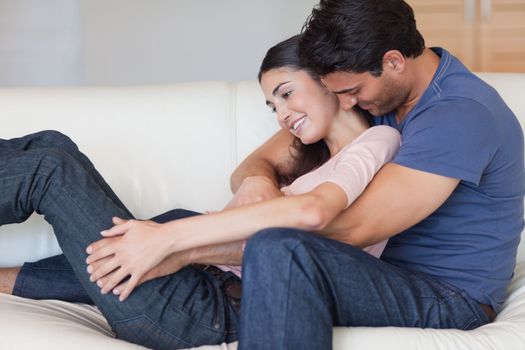 Man kissing his girlfriend in the neck in their living room