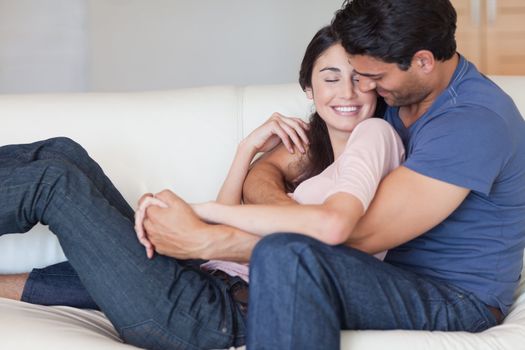 Man kissing his fiance in the neck in their living room