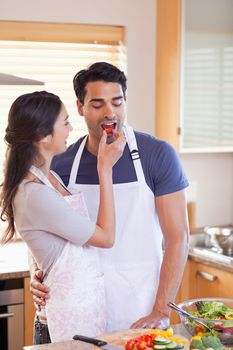 Portrait a woman feeding her husband in their kitchen