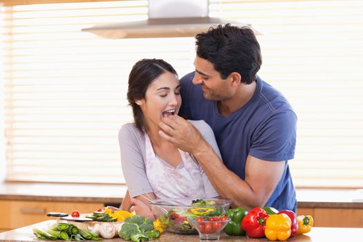 Man feeding his wife in their kitchen