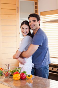 Portrait of a couple embracing each other in their kitchen