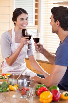 Portrait of a couple having a glass of wine while cooking in their kitchen