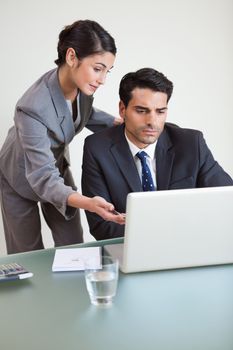 Portrait of a good looking business team working with a notebook in an office