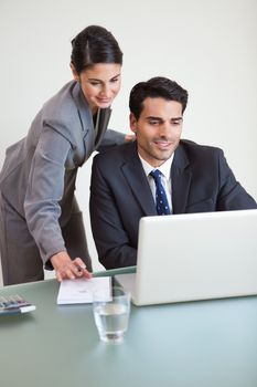 Portrait of sales persons working with a laptop in an office