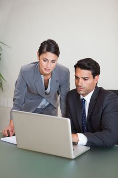 Portrait of sales persons working with a notebook in an office