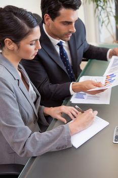 Portrait of sales persons studying statistics in a meeting room