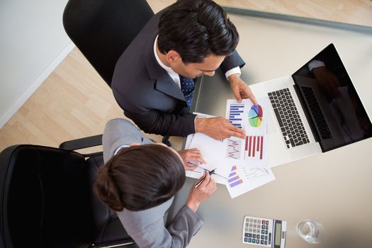 Sales persons studying statistics in an office