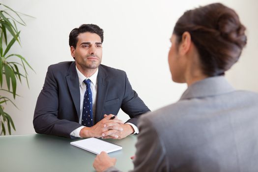 Handsome manager interviewing a female applicant in his office