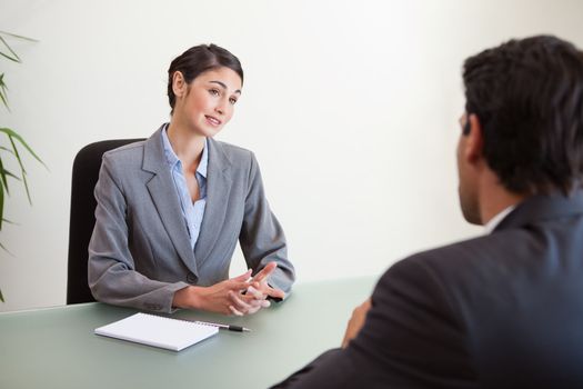 Manager interviewing a good looking applicant in her office