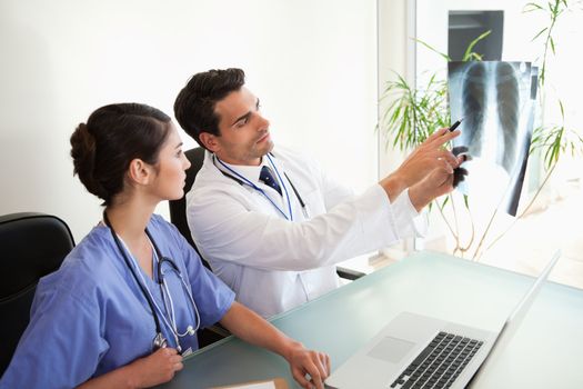 Doctors looking at a set of X-ray in an office