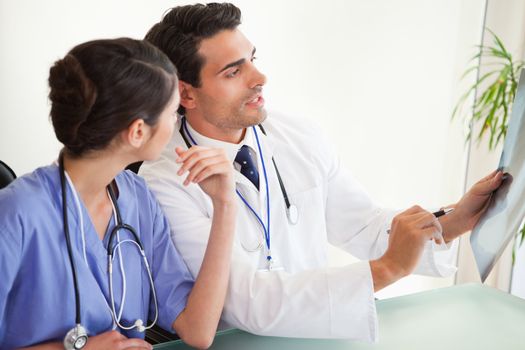 Professional doctors looking at a set of X-ray in an office