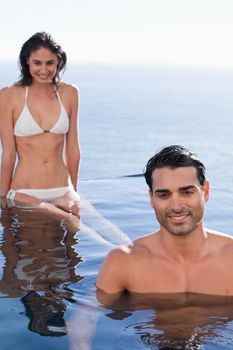 Portrait of a young couple relaxing in a swimming pool