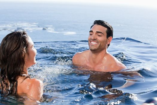 Smiling couple playing in a swimming pool