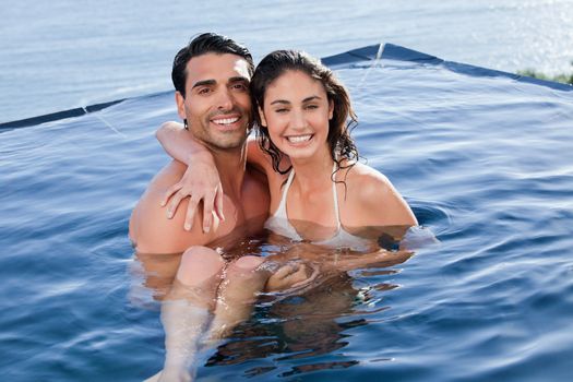 Young couple playing together in a swimming pool