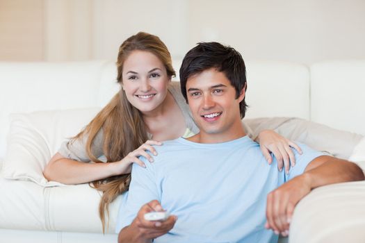 Happy couple watching television in their living room