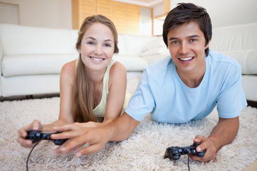 Young couple playing video games in their living room
