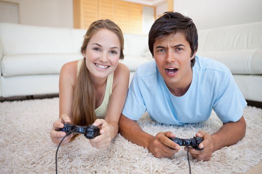 Playful couple playing video games in their living room