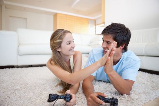 Playful young couple playing video games in their living room