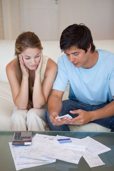 Portrait of a couple looking at their bills in their living room