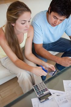 Portrait of a sad young couple looking at their bills in their living room