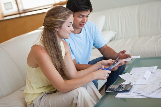 Couple cutting their credit card in their living room