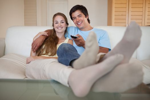Relaxed young couple watching television in their living room