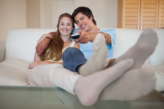 Relaxed lovely couple watching television in their living room