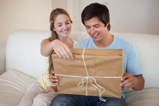 Couple opening a package in their living room