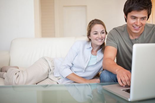 Relaxed couple using a notebook in their living room