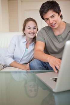 Portrait of a laughing couple using a notebook in their living room