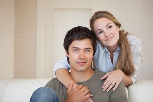 Young couple hugging in their living room