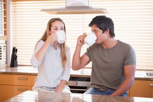 Young couple having a cup of tea in their kitchen