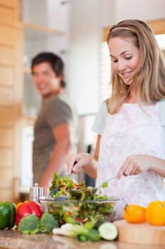 Portrait of a lovely couple making a salad in their kitchen