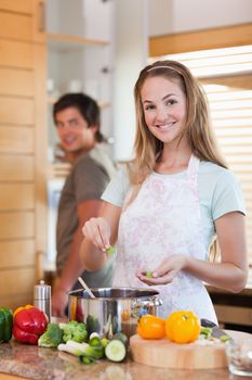 Portrait of a smiling couple cooking in their kitchen