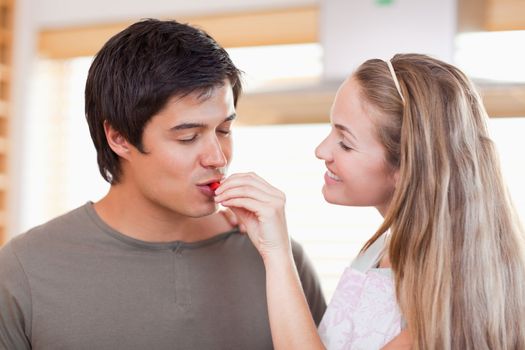 Man tasting the meal of her fiance in their kitchen