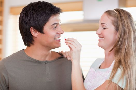 Woman feeding her husband in their kitchen