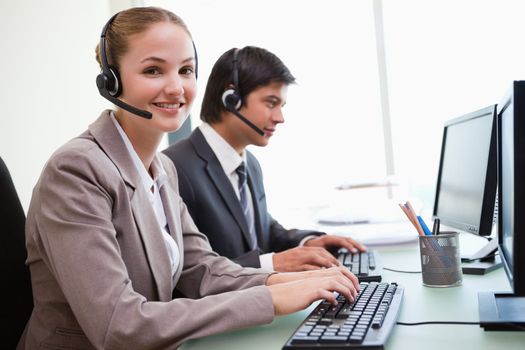 Smiling office workers using computers in an office