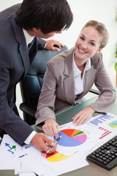 Portrait of a smiling business team studying statistics in a meeting room