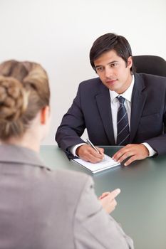 Portrait of a young manager interviewing a female applicant in his office