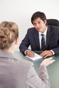 Portrait of a smiling manager interviewing a female applicant in an office