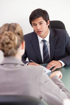 Portrait of a serious manager interviewing a female applicant in his office
