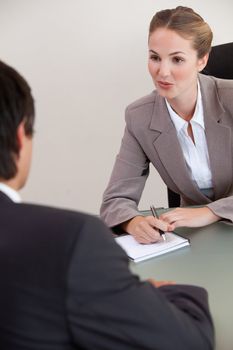 Portrait of a serious manager interviewing a male applicant in her office
