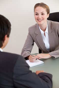 Portrait of a smiling manager interviewing a male applicant in her office