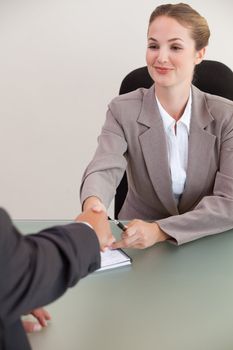 Portrait of a young manager shaking the hand of a customer in her office
